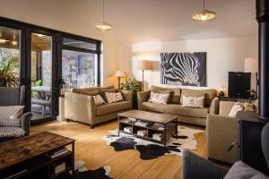 a living room with two couches and a table at Manse On The Beach in Kirkistown