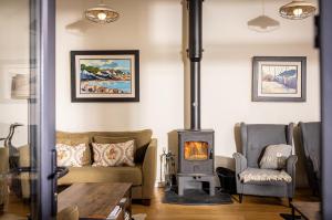 a living room with a couch and a wood stove at Manse On The Beach in Kirkistown +3 photos