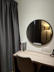 a mirror sitting on top of a desk with a chair at Wafiq Studio in Kota Bharu