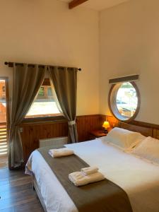 a bedroom with two beds and a large window at HOTEL & HOSTAL CHIL'IN, Las Trancas in Las Trancas