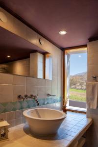 a large tub in a bathroom with a window at La Comarca Hotel in Purmamarca +133 photos