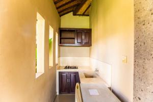 a kitchen with a table and chairs in a room at Warung Mandi & Villa in Ubud