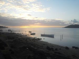 un grupo de barcos en el agua al atardecer en Le Pandanus en Rodrigues Island