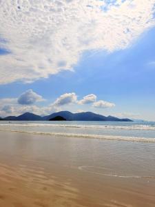 a view of the beach with mountains in the background at Casa em Condomínio com Wi-Fi - 300m da praia in Ubatuba