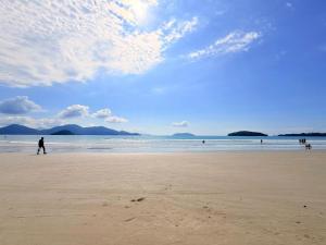 a person walking on a beach with the ocean at Casa em Condomínio com Wi-Fi - 300m da praia in Ubatuba +25 photos