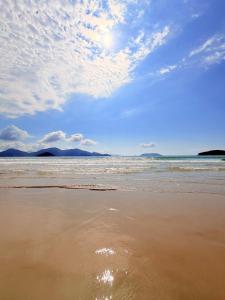 a sandy beach with the ocean and a cloudy sky at Casa em Condomínio com Wi-Fi - 300m da praia in Ubatuba