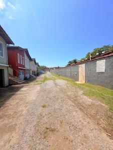 an empty dirt road next to a brick wall at Casa em Condomínio com Wi-Fi - 300m da praia in Ubatuba