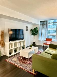 a living room with a couch and a tv at Cozy Condo near CN Tower in Toronto