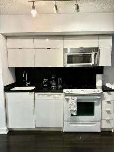 a kitchen with white appliances and a microwave at Cozy Condo near CN Tower in Toronto +9 photos