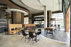 a restaurant with tables and chairs in a building at Archer Hotel Seattle/Redmond in Redmond