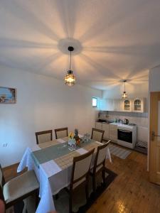 a dining room with a table and a kitchen at Apartman Demirovic in Orašac