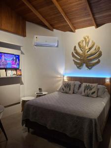 a bedroom with a large bed and a tv at Suíte Vista Mar Praia Estaleiro Balneário Camboriú in Balneário Camboriú