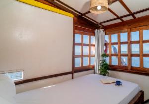 a bedroom with a white bed with a window at Yara Floating Villa in Guriú