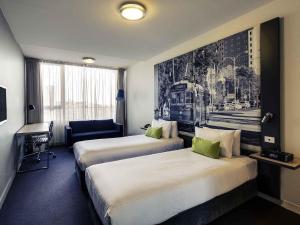 a hotel room with two beds and a desk at Mercure Melbourne Therry Street in Melbourne +46 photos