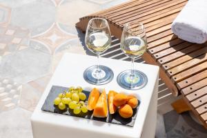 two glasses of wine and a plate of fruit on a table at Agua Dorada Retreat in Lula