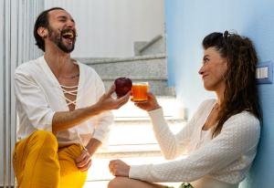 a man and a woman holding drinks and an apple at Agua Dorada Retreat in Lula