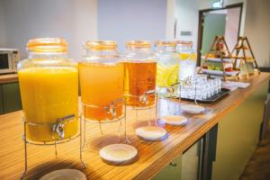 a group of four jars of orange juice on a counter at Leonardo Hotel Utrecht City Center in Utrecht