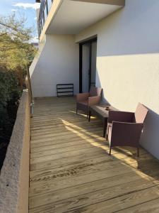 a balcony with chairs and a wooden floor at Ocean Lodge Seignosse in Seignosse