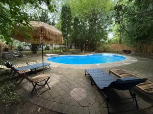 a swimming pool with two chairs and an umbrella at Spacious 4-Bedrooms Friendly House-Pool-Parking in Markham