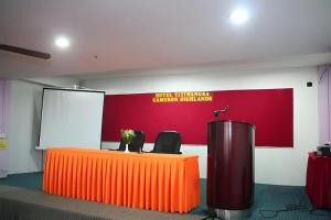a stage with an orange table and two chairs at Hotel Titiwangsa in Brinchang