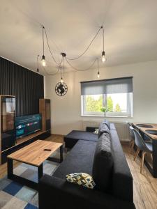 a living room with a couch and a table at Mieszkania od 32-55m, pełne wyposażenie, komfortowe warunki in Stanisławów Pierwszy