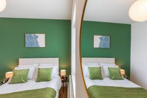 a bedroom with green walls and a mirror at Spacious 2-Bed Flat with Panoramic Views in Portsmouth