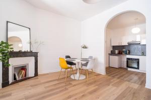 a white living room with a table and chairs at Hypercentre Capitole T2 vaste et lumineux in Toulouse