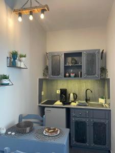 a kitchen with gray cabinets and a table with a plate at Dionisia Apartments in Kefalos