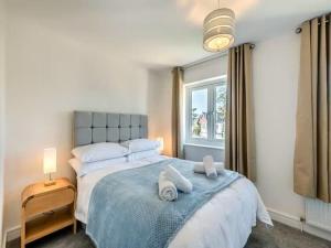 a bedroom with a large bed with towels on it at Beachside Bliss in Paignton