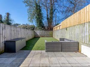 a garden with two benches and a fence at Beachside Bliss in Paignton