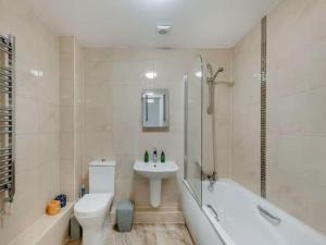 a bathroom with a sink and a toilet and a bath tub at Beachside Bliss in Paignton