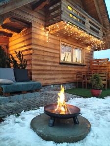 a fire pit in the snow in front of a cabin at Chata Ku Tatrom in Biały Dunajec