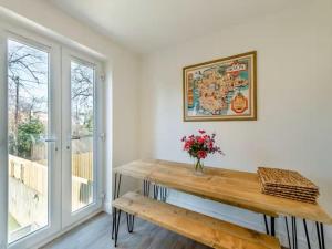 a dining room with a wooden table and a window at Beachside Bliss in Paignton