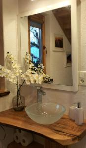 a bathroom sink with a mirror and a vase with flowers at Chata Ku Tatrom in Biały Dunajec +15 photos
