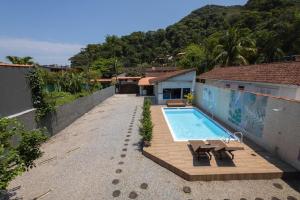 a swimming pool on the side of a house at Pousada da Árvore in Boicucanga