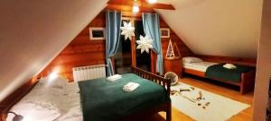 a attic bedroom with two beds and a bathroom at Chata Ku Tatrom in Biały Dunajec