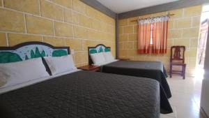 a hotel room with two beds in a room at Hotel de la Cruz in Maguey Blanco