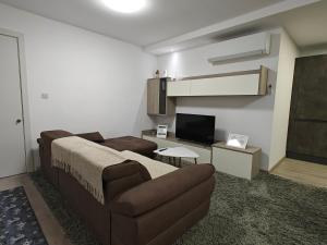 a living room with a couch and a tv at Modern 3-Bedroom Apartment - Ideal for Families and Business - Near Airport in Luqa