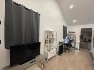 a living room with a large flat screen tv at Un cocoon spacieux in Les Essarts-le-Roi