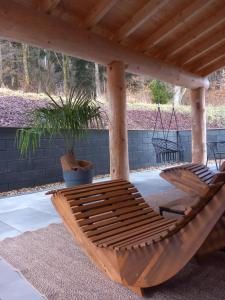 a wooden hammock under a wooden pergola at Ferienhaus Waldruhe in Hellenthal