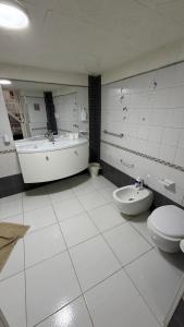 a bathroom with a tub and a toilet and a sink at Casa Della Felicità in Naples