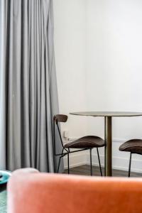 two chairs and a table in front of a curtain at King Studio Getaway! Prime Location, Balcony, Gym - S2 in Atlanta