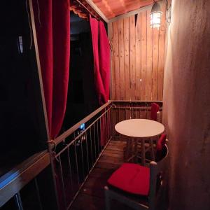 a small balcony with a table and a red chair at Z House Jbeil in Jbeil +1 photo