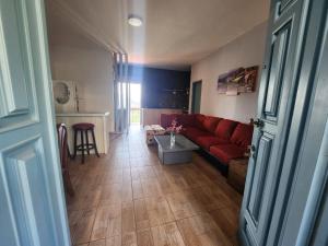 a living room with a red couch and a table at Z House Jbeil in Jbeil