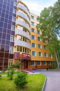 a large building with a parking lot in front of it at Park Wood Hotel - Academgorodok in Novosibirsk