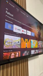 a television screen with a bunch of pictures on it at Kit net a poucos passos do mar in São Vicente