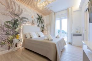 a bedroom with a bed with a tropical wallpaper at Aurum Pompei Suites in Pompei
