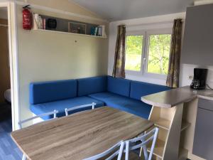 a living room with a blue couch and a table at domaine des planesses in Ferdrupt