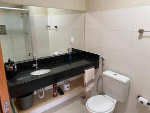 a bathroom with a sink and a toilet at Flats da Júnia 110 - funcional com ar, garagem, tv, microondas, frigobar e 14 km aeroporto in Lagoa Santa