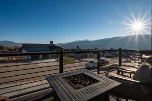 a table and chairs on a balcony with the sun at Powder Mtn Chalet B4 Ski Escape Hot Tub & View in Eden